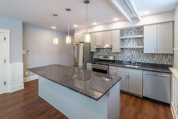 A kitchen with a granite countertop and stainless steel appliances.