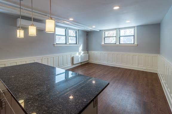 A kitchen with a granite countertop and wooden flooring.