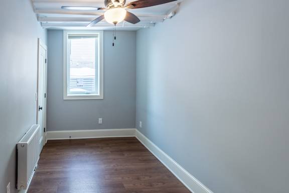 A room with a ceiling fan and a window.