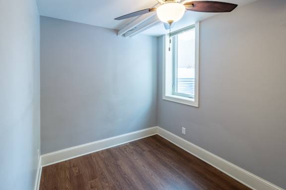A room with a ceiling fan and a window.