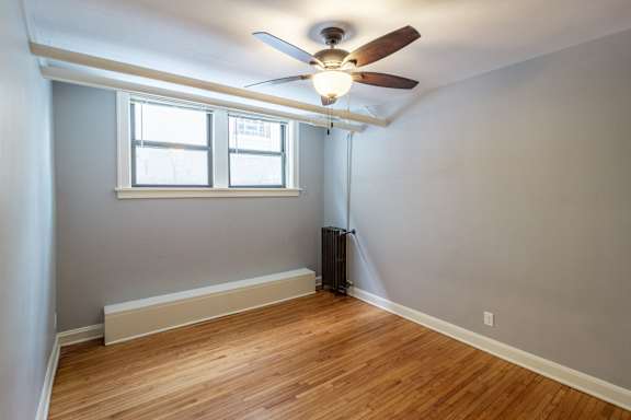 A room with a ceiling fan and a window.