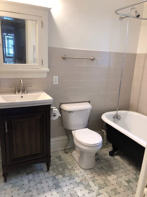 A white toilet sits next to a white sink in a bathroom.
