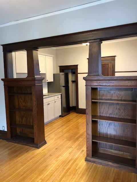 A kitchen with a wooden floor and a wooden shelf.