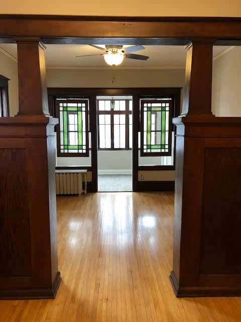 A room with wooden floors and a ceiling fan.