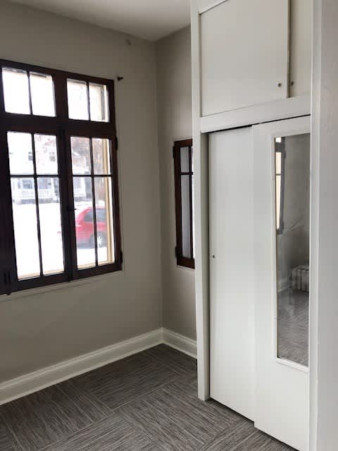 A white door is open to a room with a grey carpet.