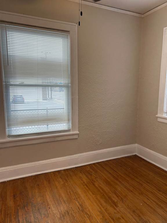 A room with a window and wooden flooring.