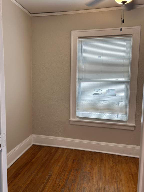 A room with a window and wooden floors.