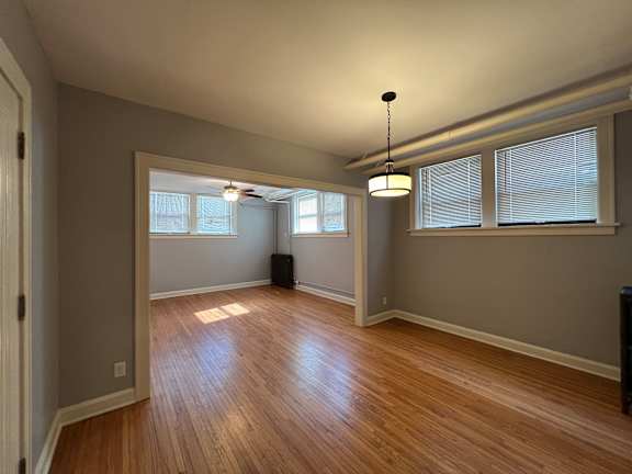 A room with wooden floors and a ceiling fan.