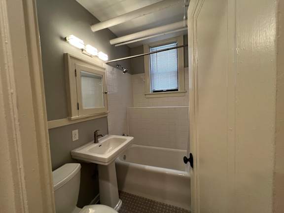 A bathroom with a toilet, sink, and bathtub.