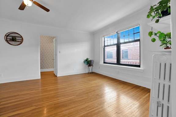 A room with a wooden floor and a ceiling fan.