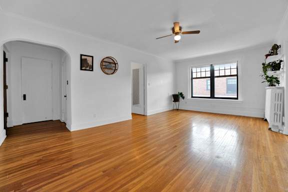 A room with a wooden floor and a ceiling fan.