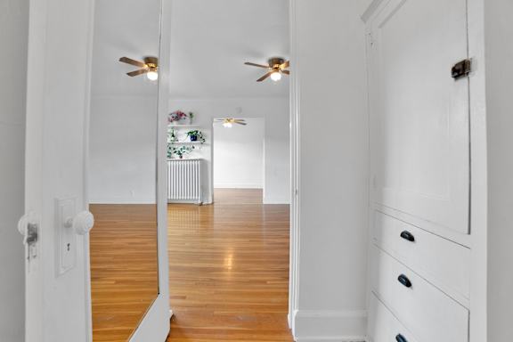 A hallway with a wooden floor and white walls.