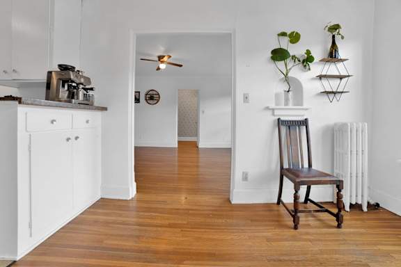 A chair sits in a room with a white ceiling fan and a white wall.