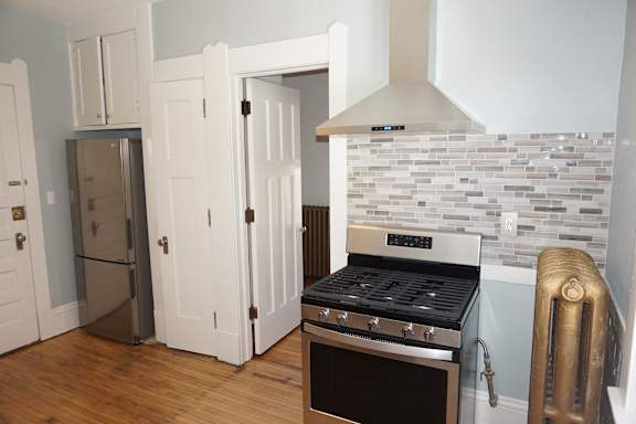 A kitchen with a stove and a refrigerator.