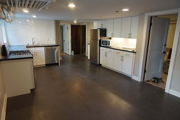 A kitchen with white cabinets and a black stove top.