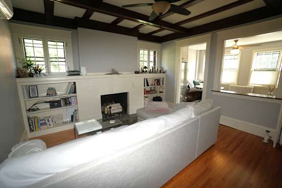 A living room with a fireplace and a white couch.