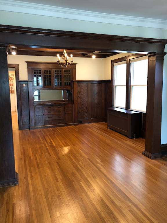 A room with wooden floors and a chandelier.