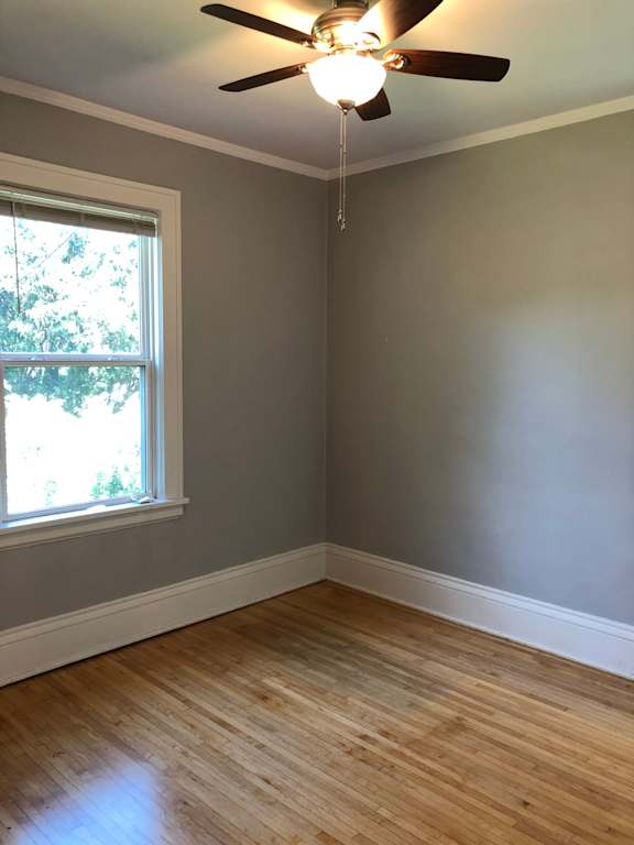 A room with a ceiling fan and a window.