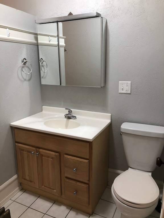 A white toilet sits next to a sink in a bathroom.