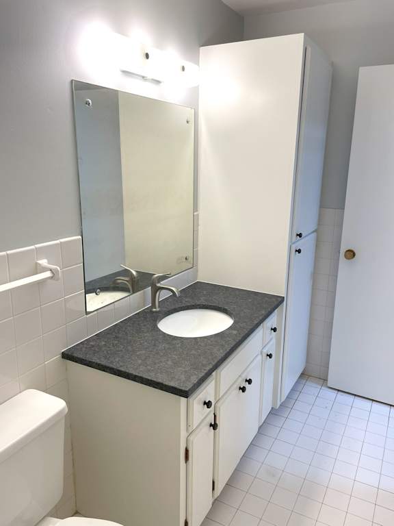 A bathroom with a sink, mirror, and toilet.