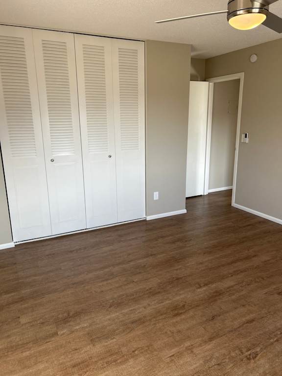 A room with a white door and a brown floor.