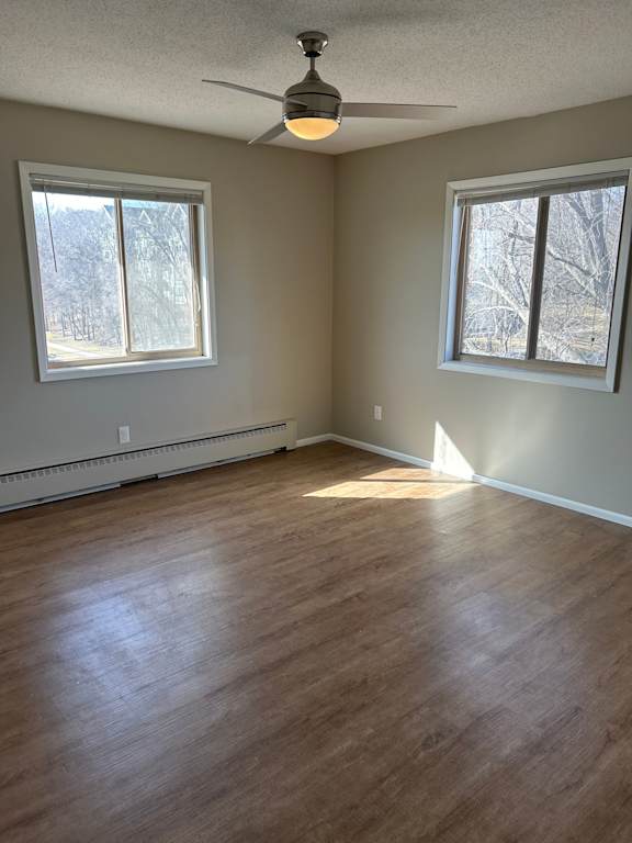 A room with wooden flooring and a ceiling fan.