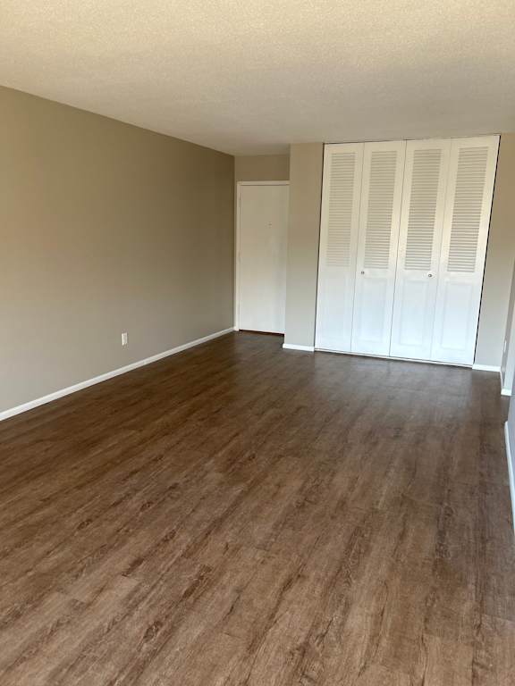 A room with wooden flooring and white closet doors.