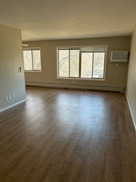 A room with wooden flooring and a window.