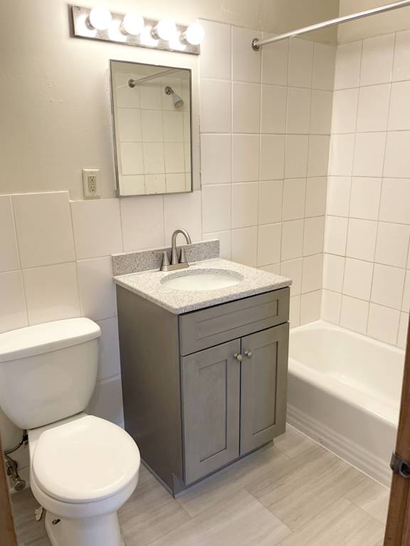 A white toilet sits next to a sink in a small bathroom.
