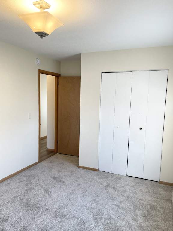 A room with a carpeted floor and a white wall.