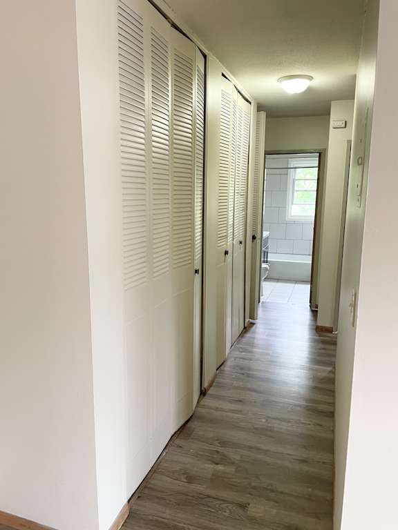 A long hallway with white walls and wood floors.