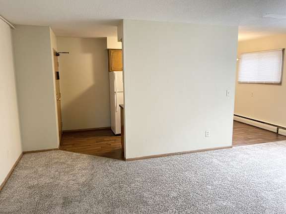 A room with a grey carpet and white walls.