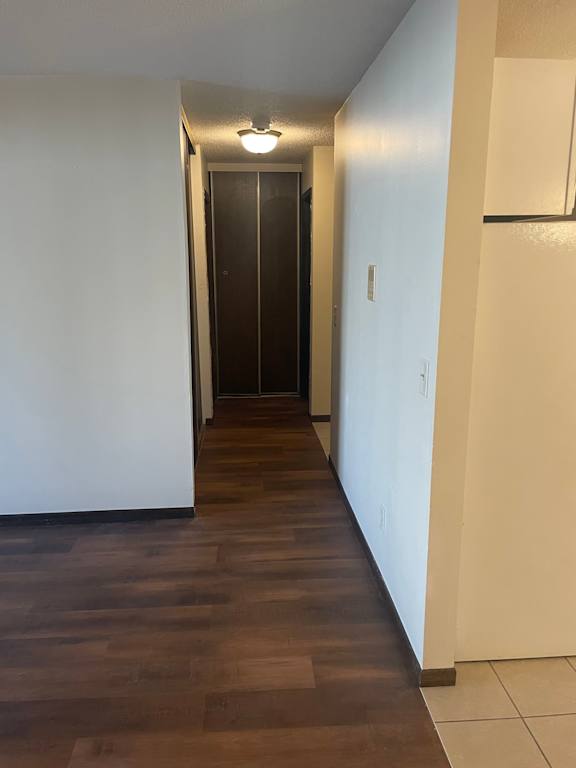 A long hallway with a brown floor and white walls.