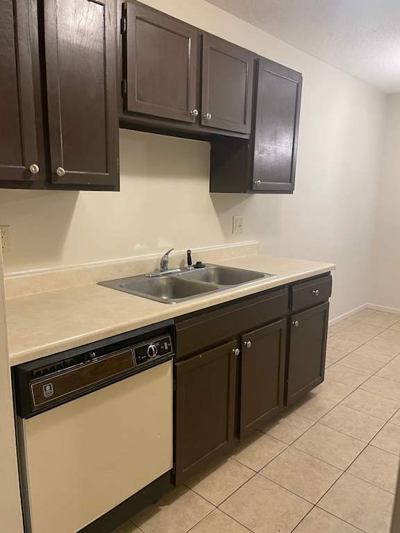 A kitchen with brown cabinets and a white sink.