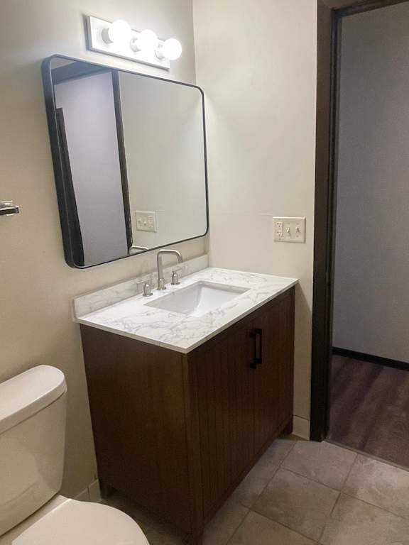 A bathroom with a sink, toilet and mirror.
