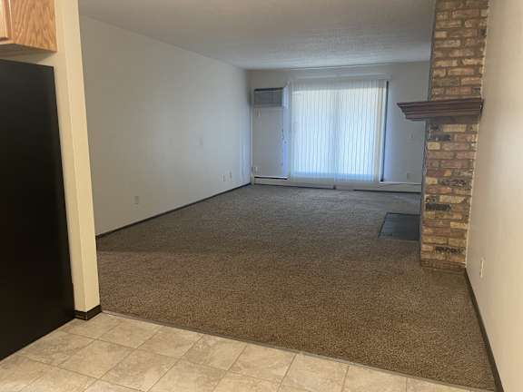 A room with a fireplace and a window with blinds.