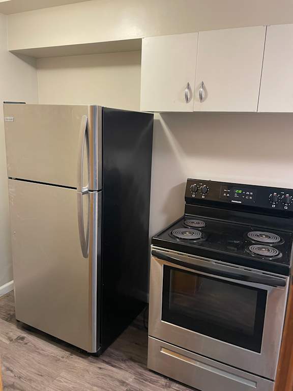 A black stove and a white refrigerator in a kitchen.