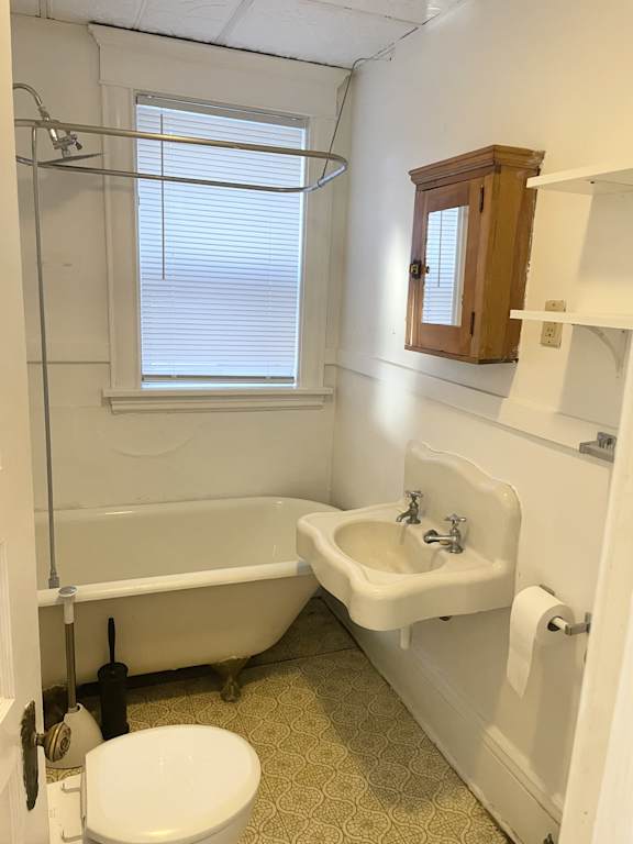 A white bathroom with a toilet, sink, and bathtub.