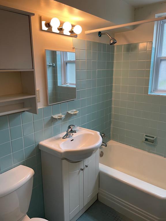 A white sink sits under a mirror in a bathroom.