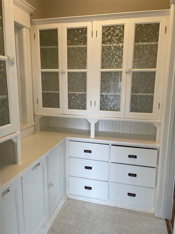 A kitchen with white cabinets and drawers.