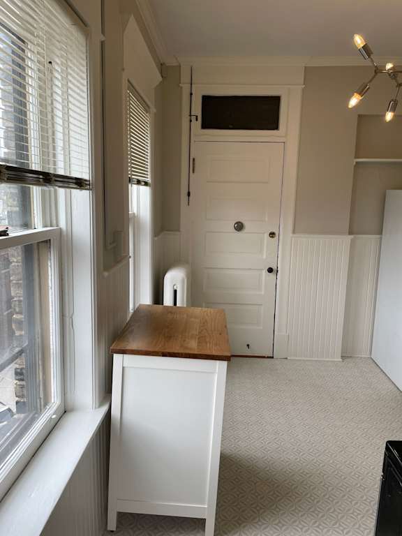 A white door with a black handle is in the middle of a room.
