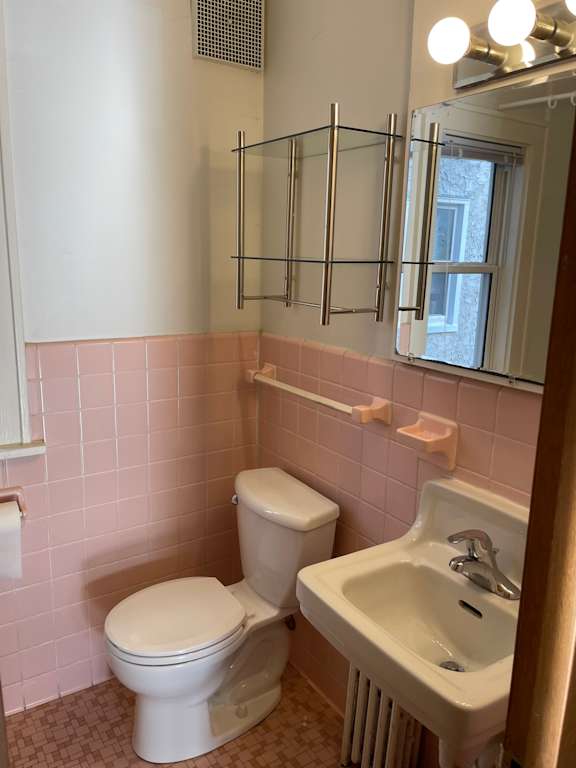 A white toilet and sink in a bathroom.