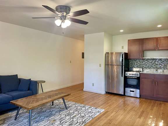 A kitchen with a refrigerator, oven, and stove top.