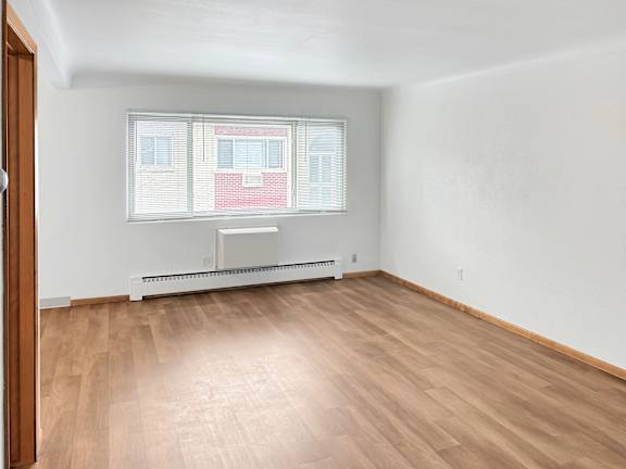 A room with a window and a radiator on the wall.