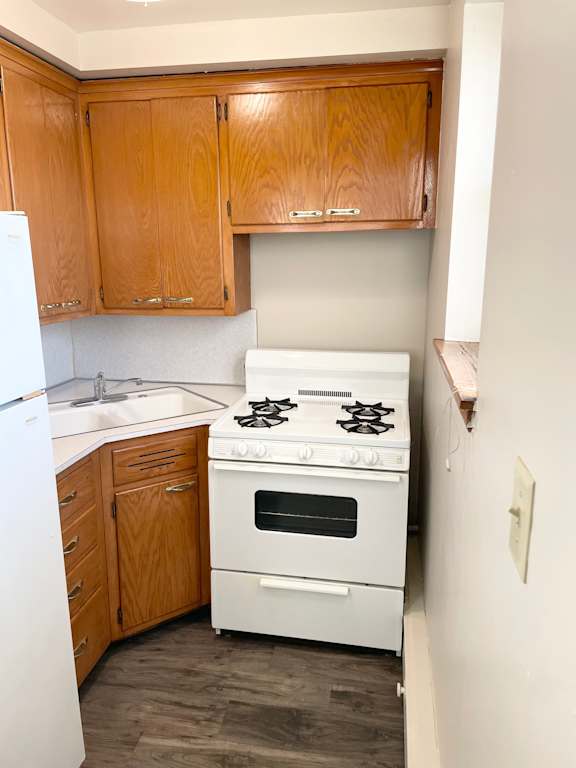 A white stove and oven in a kitchen with wooden cabinets.