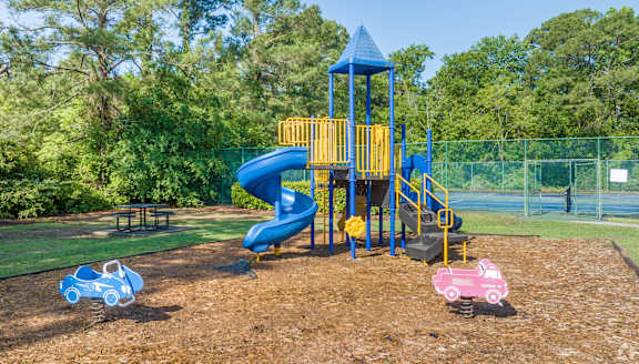 A playground with a blue slide and a yellow structure.