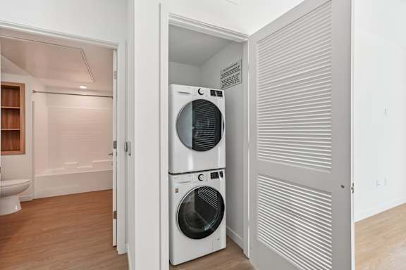 A white washing machine and dryer in a small laundry room.