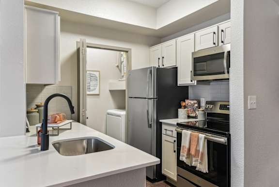 A kitchen with a black refrigerator and white countertops.at Onyx183, Austin