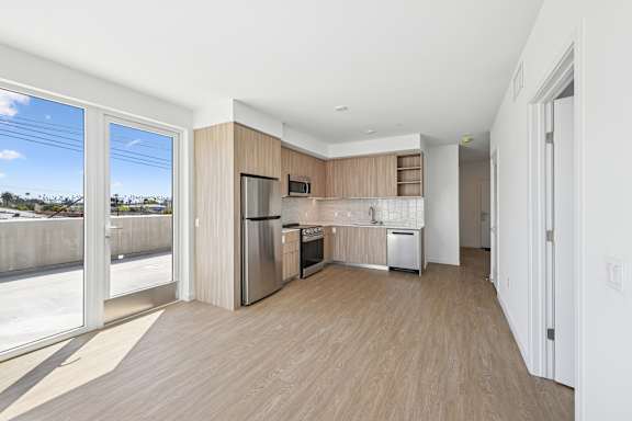 A kitchen with wooden floors and a refrigerator.