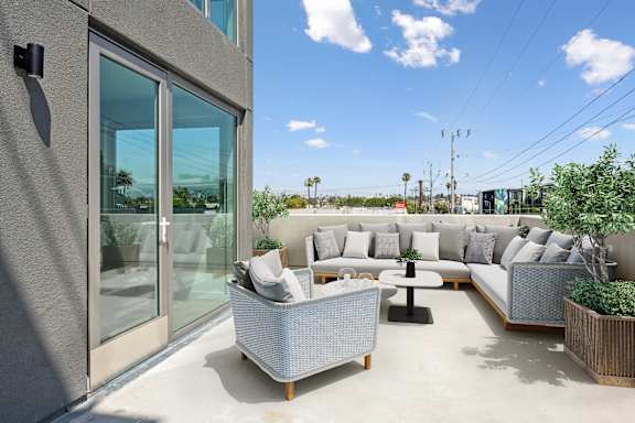 A patio with a couch, chairs, and a table.